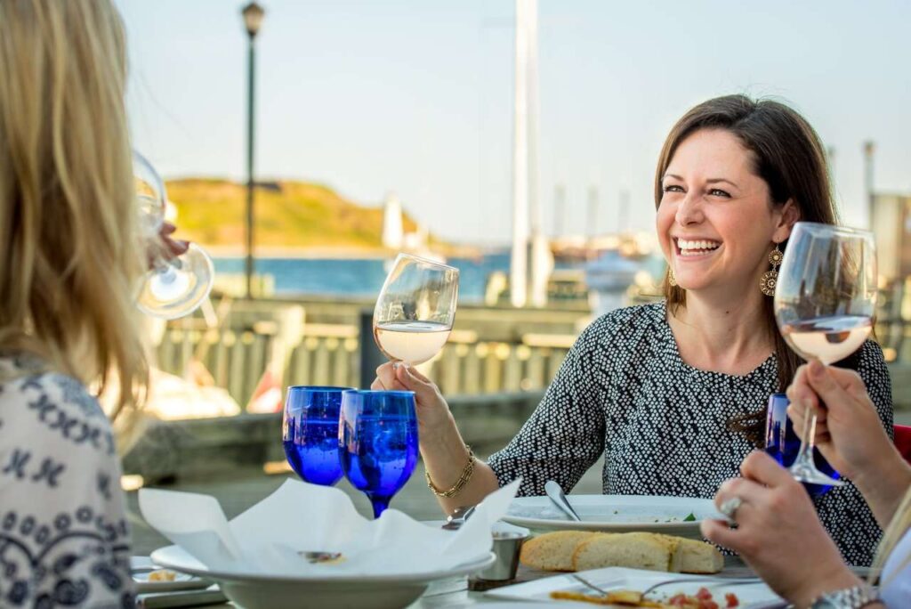Friends sharing wine and conversation over a meal beside Halifax’s waterfront