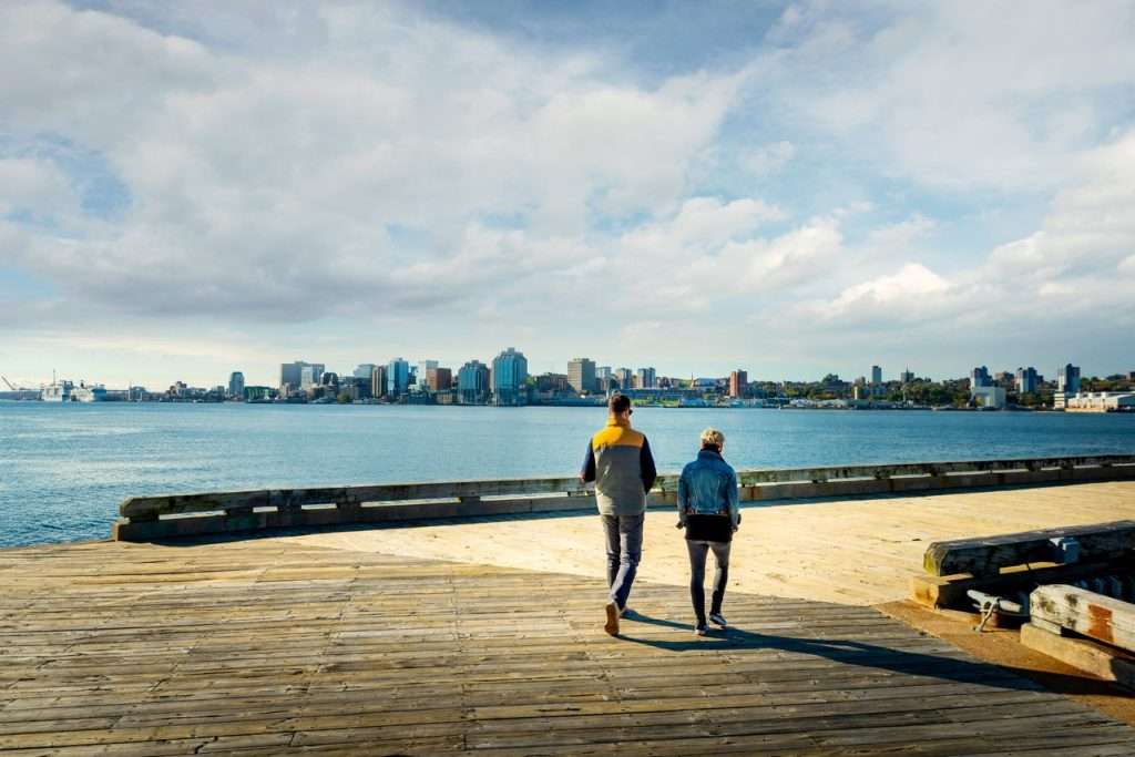 A couple walking along the waterfront boardwalk.