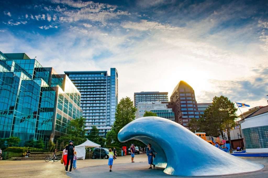 Blue wave sculpture on Halifax waterfront with people walking around