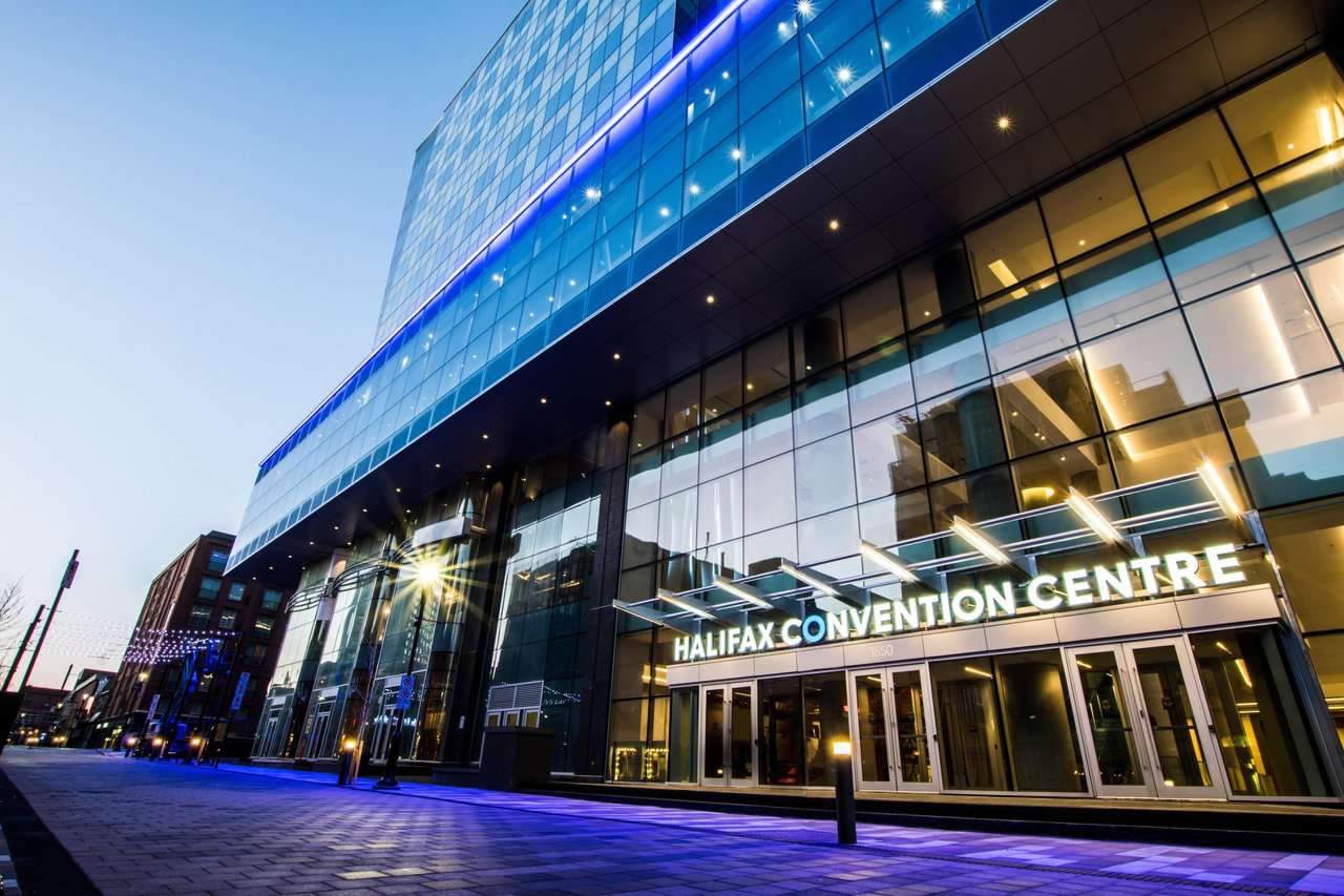 Hotels near Halifax Convention Centre guide featuring the venue's glass exterior at dusk